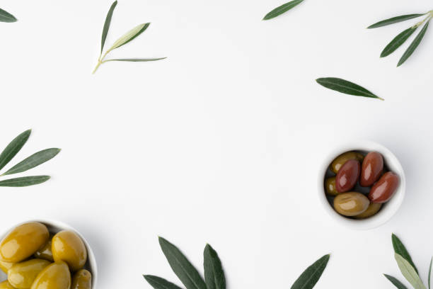 istock Bowl with green olives and olive leaves on white background 1368168546