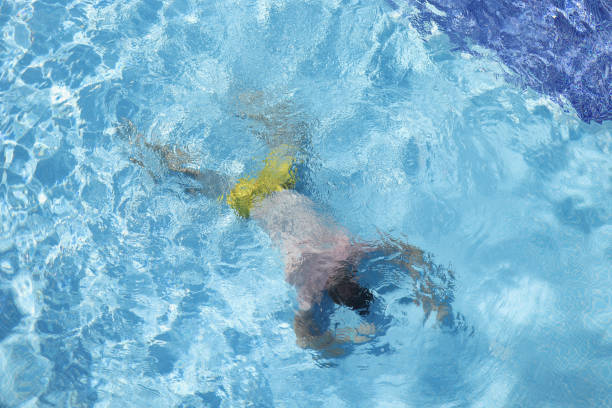 Man lying at bottom of swimming pool top view. Drowning aid concept