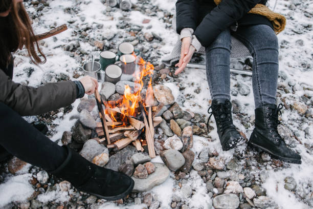istock Friends warming up by the fire on camping 1368169783