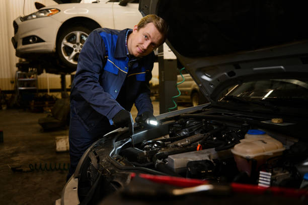 istock Technician automotive checking car in the garage. Auto mechanic working with engine in garage, car service technician repairing customer care at automobile service center. 1368171985