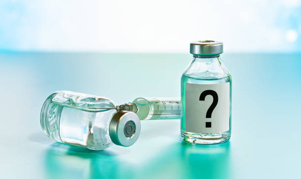 istock Vaccine bottle with hypodermic syringe needle near, question mark on label, unknown side effects of experimental treatment concept 1368174350