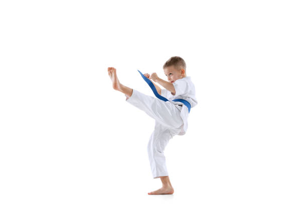 한 스포츠 어린 소년, 도복스를 입고 태권도 선수는 흰색 배경에 고립 된 혼자 연습. 스포츠, 무술의 개념 - karate kicking tae kwon do martial 뉴스 사진 이미지