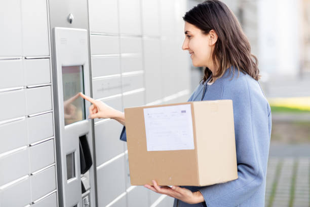 istock smiling woman with box at automated parcel machine 1368177460