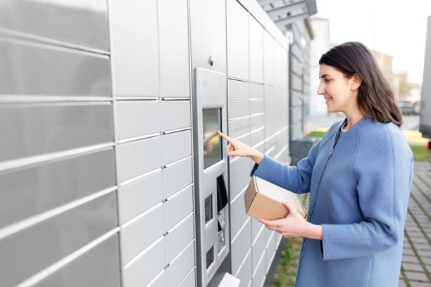 istock smiling woman with box at automated parcel machine 1368177613
