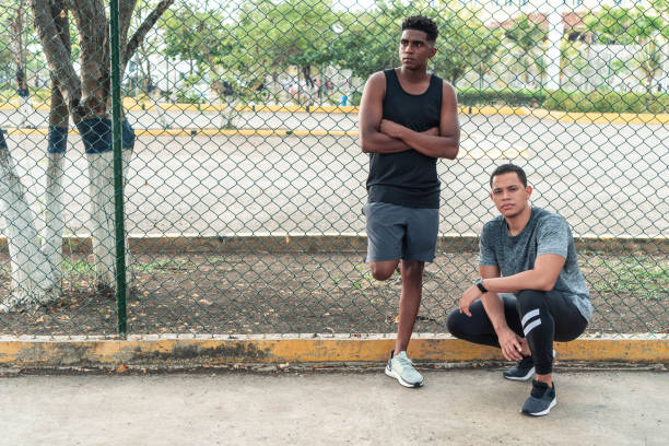 istock Two young men in sportswear relaxing outdoors looking at the camera 1368178558