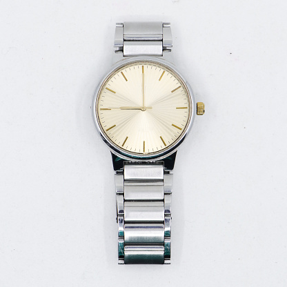 a silver stainless steel analog watch with a round golden dial made as a vintage luxury symbol isolated in a white background