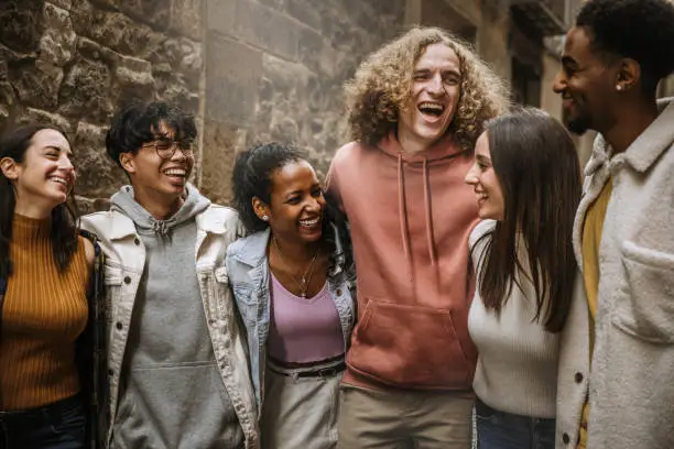 Multiethnic group of friends hangout together walking outdoors - Cheerful young people enjoying outside on city street - Happy students having fun in college campus - Happy lifestyle concept