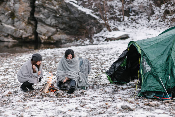 istock Campers wrapped in blankets in front of a tent 1368180666