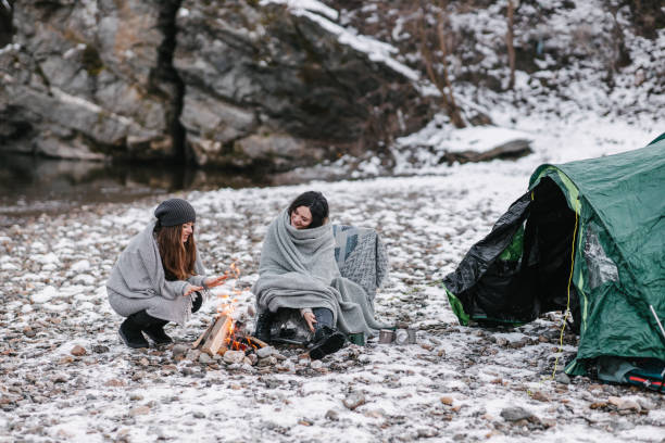 istock Campers wrapped in blankets in front of a tent 1368180668