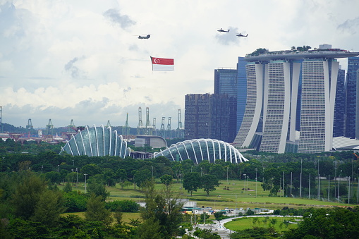 Three Chinook helicopters carrying the state flag of Singapore in a fly past, as part of the national day parade on national day of Singapore