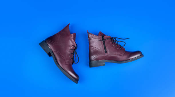 istock stylish leather boots on blue background, footwear 1368182359