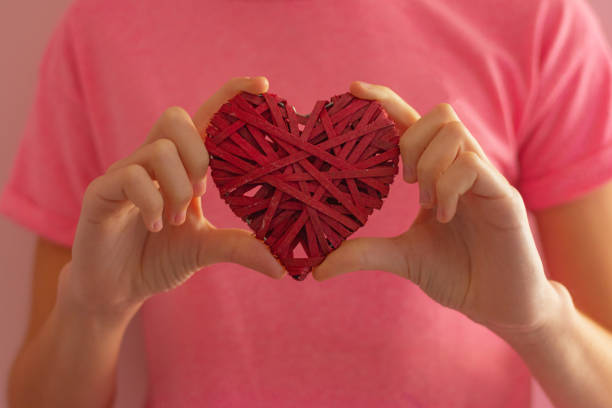 istock girl holding a wicker red heart in her hands 1368183593