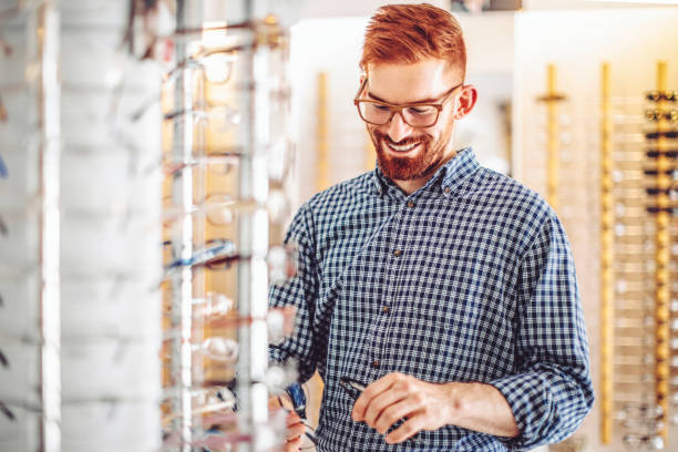 istock Young man buying eyelasses at the optical store 1368186817
