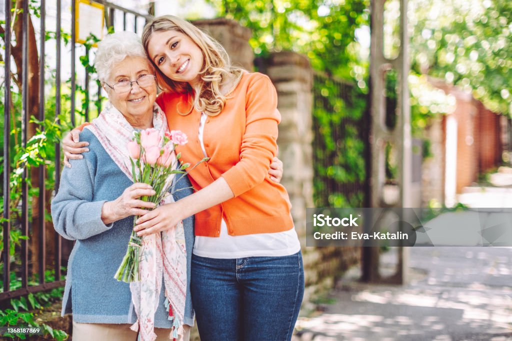 Teenage girl is visiting her grandmother at home Senior Adult Stock Photo