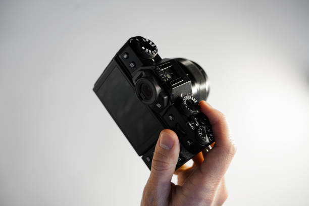 istock a man holds a compact professional reflex camera in his hands on a light background top view 1368188179