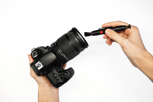 istock a man cleans a SLR camera with a brush from dust camera service top view 1368188475
