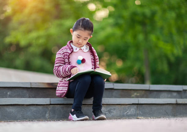 istock Little Girl Reading Book 1368189552