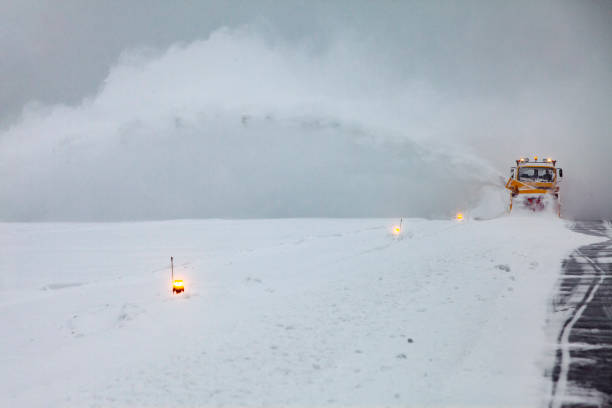 Snow plows are cleaning on the runway in after heavy snowstorm.