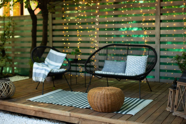 istock Exterior Terrace with green plants, sofa and lanterns. Cozy space in patio or balcony. Interior Wooden veranda with garden armchair and table. Summer lounge with garden furniture outdoors in backyard. 1368189727