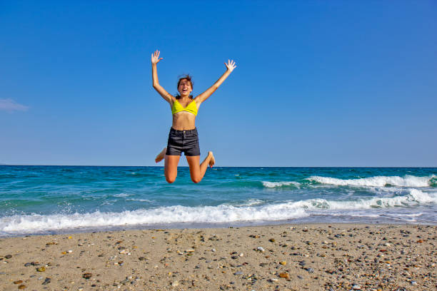 Girl jumping on the sunny beach