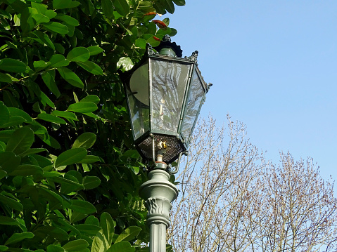 A depiction of an old, vintage gas lantern, shot in early summer 2021, on a public park of Dusseldorf, Germany.