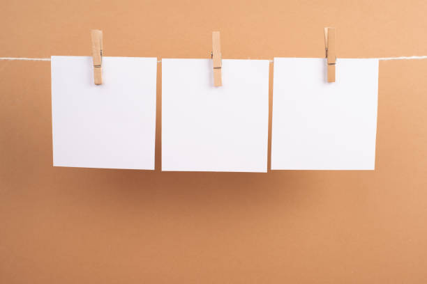 istock Empty white sheets of paper in a row hanging on a string, copy space for pictures and text, message communication and marketing background 1368192889