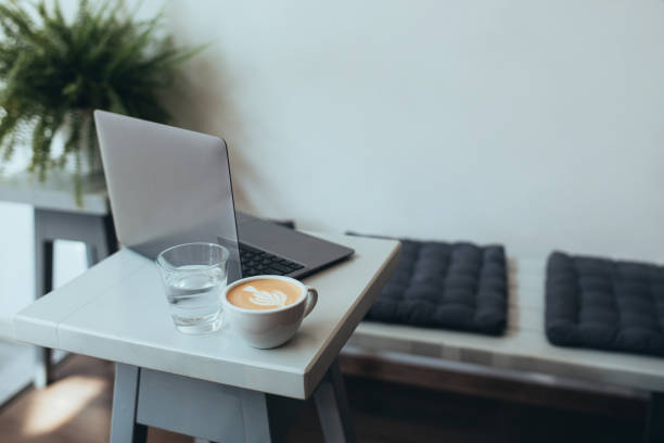 istock Cup with fresh coffee cappuccino and laptop on a white table. 1368194576