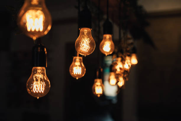 istock Lamp bulbs hanging on a dark background. 1368194578