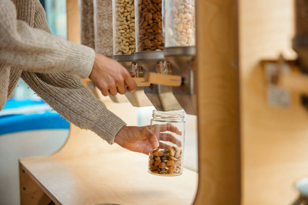 Close Up Of A Female Using A Nuts Dispenser In A Zero Waste Store stock photo
