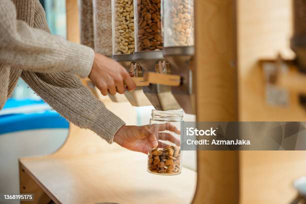 Close Up Of A Female Using A Nuts Dispenser In A Zero Waste Store Stock Photo - Download Image Now