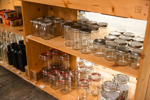 Shelves of empty reusable glass jars in a zero waste, eco friendly shop.