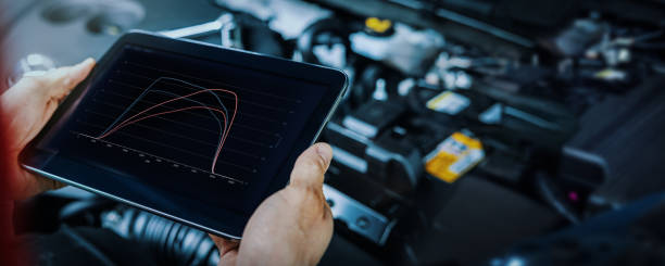 car engine ecu remapping and diagnostics. mechanic using digital tablet to check vehicle performance after chiptuning stock photo