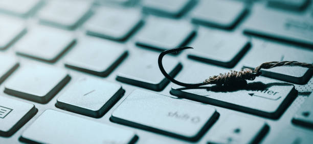 phishing and cyber crime concept. fishing hook on computer keyboard. copy space stock photo