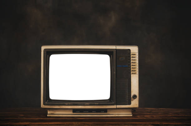 istock Retro old television on wood table with dark wall background, cut out white screen, still life TV 1368198924
