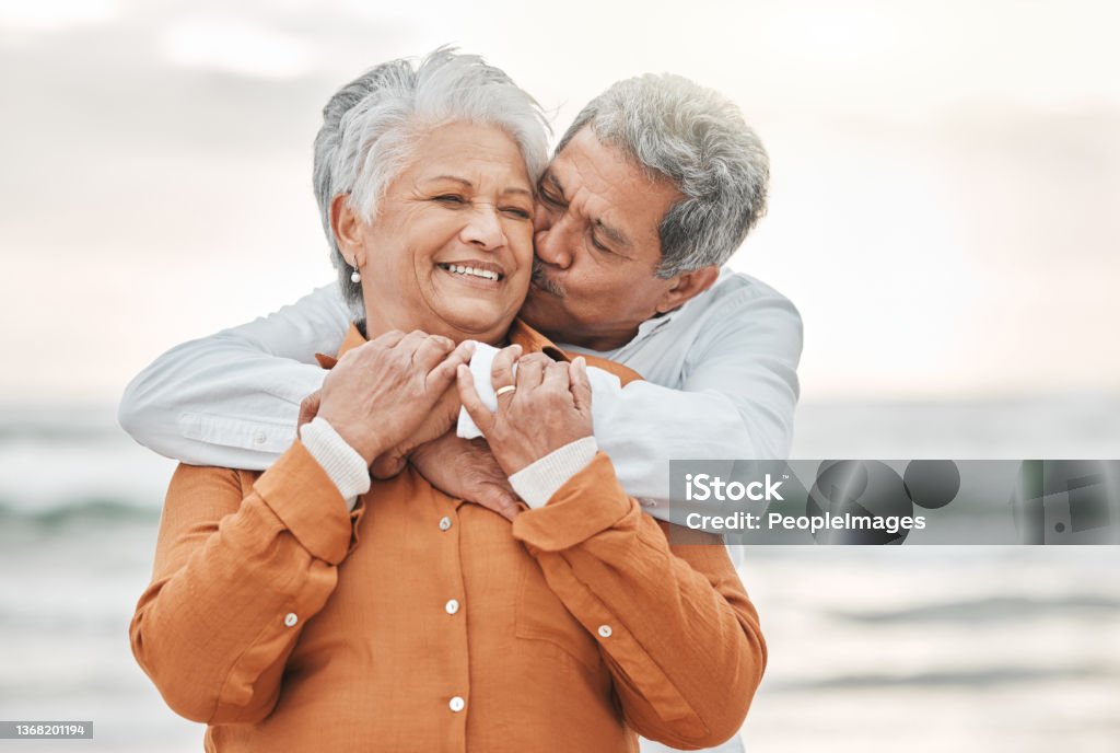 Cropped shot of an affectionate senior couple sharing an intimate moment on the beach Never let that flame die Senior Couple Stock Photo