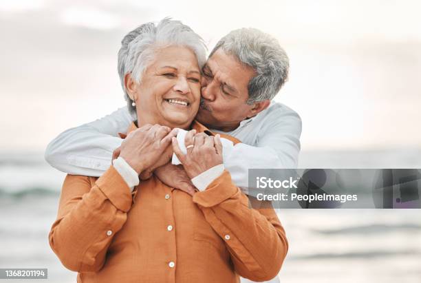 Cropped Shot Of An Affectionate Senior Couple Sharing An Intimate Moment On The Beach Stock Photo - Download Image Now