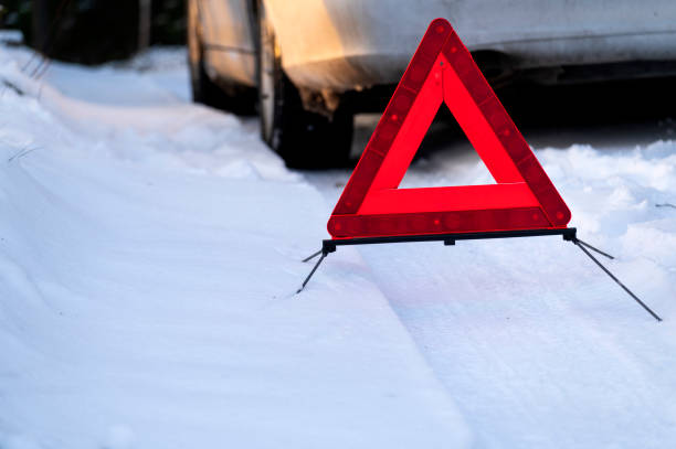 warnung rotes dreiecksschild und auto im schnee gefangen am wintertag. - emergency sign winter driving emergency services stock-fotos und bilder