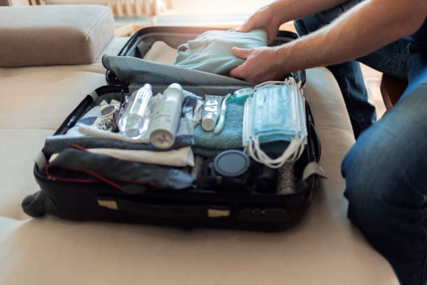 istock Men is arranging clothes in suitcase for travel. 1368202429