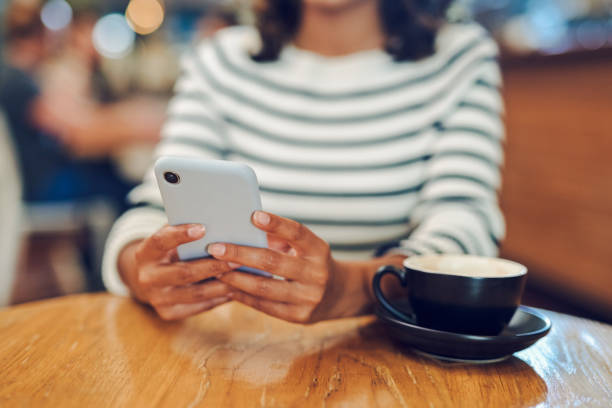 istock Shot of a unrecognizable woman using a phone in a cafe 1368202552