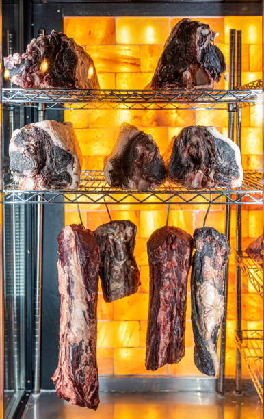 beef hung and lined up in a dry aged beef cabinet - dry aged imagens e fotografias de stock