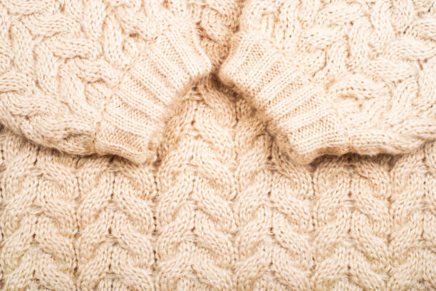 A highly detailed macro image focusing on knitted fabric showcasing colorful textured yarn close-up. The composition features harmonious gradient shades of purple and beige, highlighting soft material craftsmanship and artistic design patterns.
