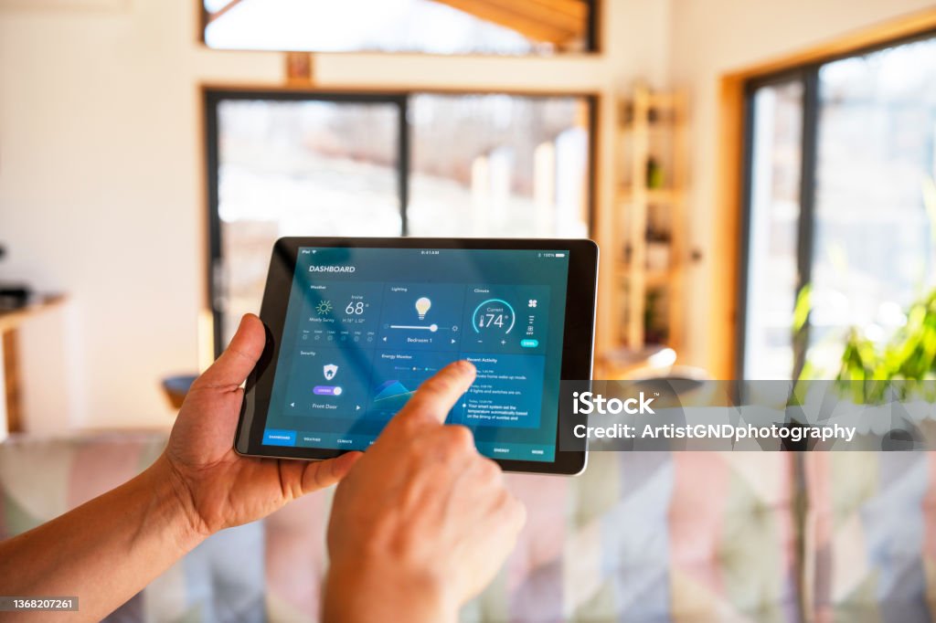 Man using tablet with smart home control functions at home. Unrecognisable man using tablet with smart home control functions at home. Home Automation Stock Photo
