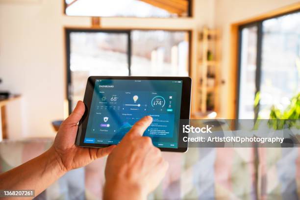 Man Using Tablet With Smart Home Control Functions At Home Stock Photo - Download Image Now