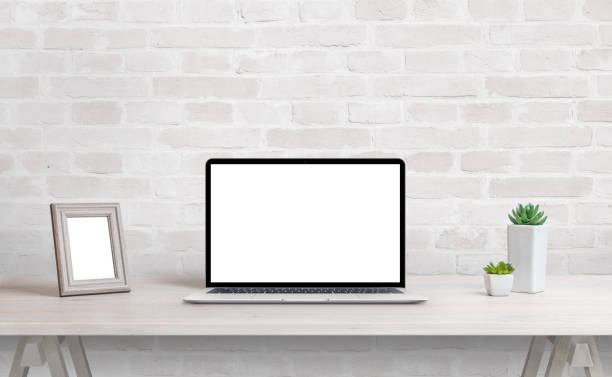 istock Laptop mockup on work desk. Work at home concept. Clean desk with photo frame and plants 1368207632