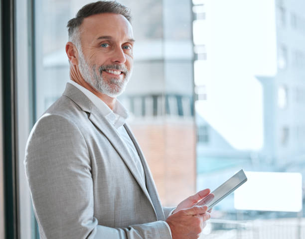 istock Shot of a. mature man using a tablet in a office 1368210465
