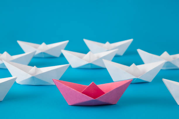 istock Red Paper Boat Leading Other Boats 1368214157