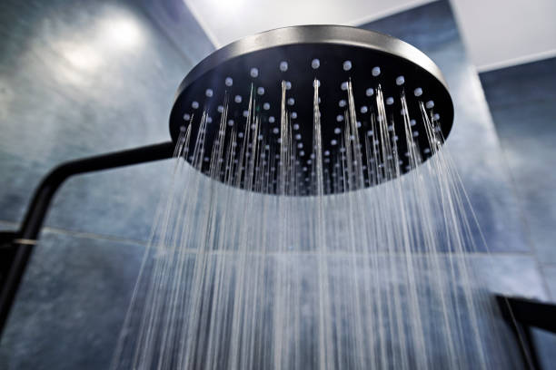 water running from a black rain shower head - chuva imagens e fotografias de stock