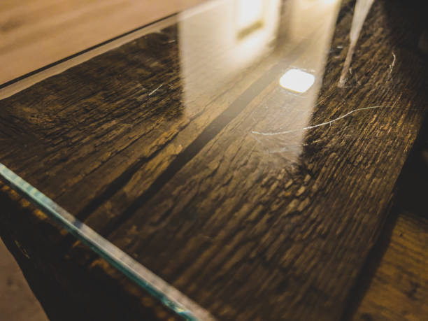 istock A table edge of a wooden table with glass top. 1368216263