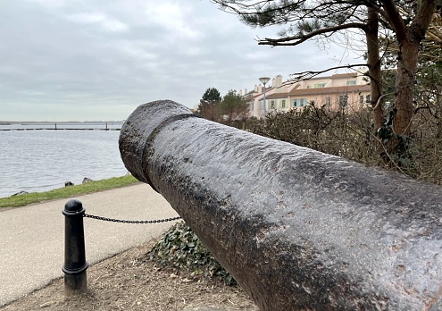 old cannon pointed at a boat in the sea in the netherlands