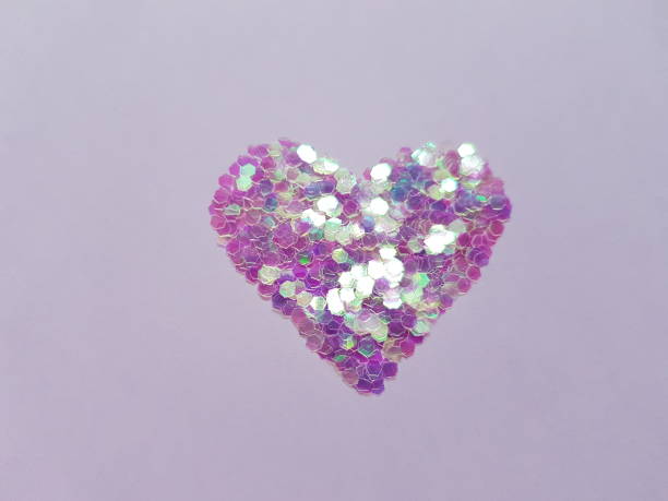 istock Violet heart made of sequins on a purple table 1368218526